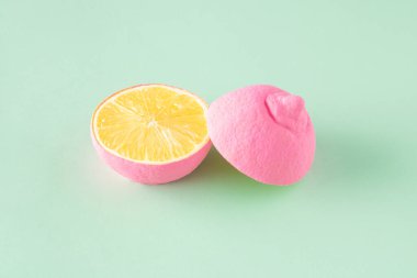 Two halves of a pink lemon arranged on a light green background. Minimal fruit summer concept clipart