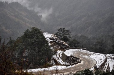 Ariel, dağın tepesindeki hareketli yol manzarası bulutlu gökyüzü ile güzel bir dağ yamacı..