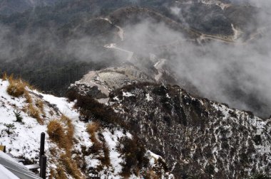 Ariel, dağın tepesindeki hareketli yol manzarası bulutlu gökyüzü ile güzel bir dağ yamacı..