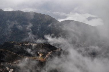 Ariel, dağın tepesindeki hareketli yol manzarası bulutlu gökyüzü ile güzel bir dağ yamacı..