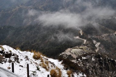Ariel, dağın tepesindeki hareketli yol manzarası bulutlu gökyüzü ile güzel bir dağ yamacı..
