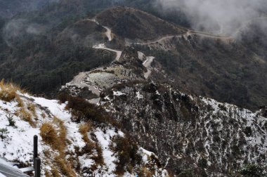 Ariel, dağın tepesindeki hareketli yol manzarası bulutlu gökyüzü ile güzel bir dağ yamacı..