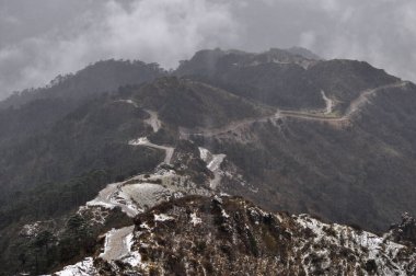 Ariel, dağın tepesindeki hareketli yol manzarası bulutlu gökyüzü ile güzel bir dağ yamacı..