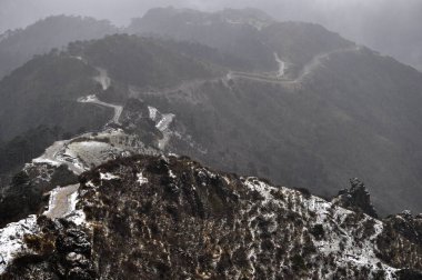 Ariel, dağın tepesindeki hareketli yol manzarası bulutlu gökyüzü ile güzel bir dağ yamacı..
