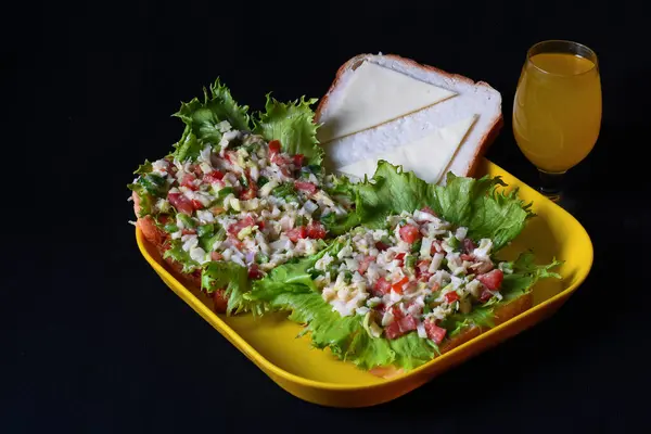 Marul, domates, yeşil dolmalık biber ve taze mango suyuyla açık tost sandviçi.