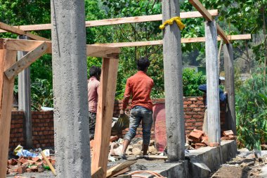 İnşaat alanında kum taşıyan bir adam..