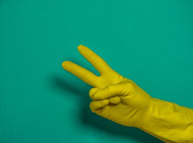 Sarı lastik eldiven takan bir adam sarı bir sırt grubuna karşı.