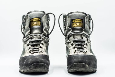 Eski aşınmış yürüyüş botları beyaz arka planda izole edilmiş