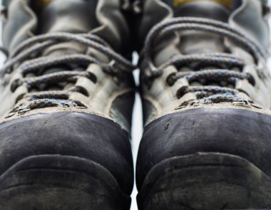 Eski aşınmış yürüyüş botları beyaz arka planda izole edilmiş