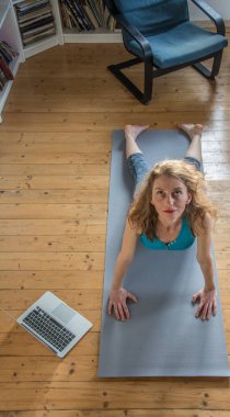 Evde yoga yapan bir kadın.