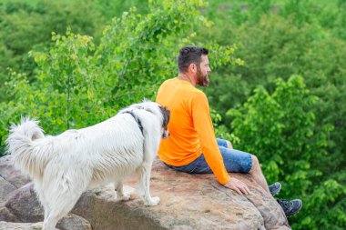 Köpeğiyle parkta oynayan bir adam.