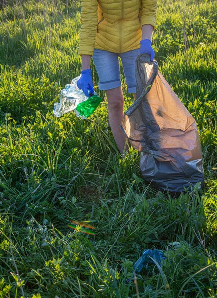 volunteer collecting plastic garbage Earth day