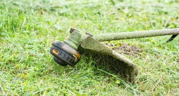 Trimmer close up mow the grass with a lawnmower . Gardening with a brush cutter Close-up. Lawn care with brush cutters