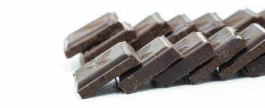 Dünya Çikolata Günü. Beyaz arkaplanda çikolata parçaları,