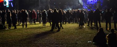 Konserdeki kalabalık ve sahne ışıklarındaki siluetler. Parlak sahne ışıkları önünde konser seyircilerinin siluetleri. Parlak sahne ışıkları önünde tezahürat yapıyorlar.