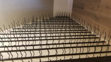 Dikey çekimde boş bir mahzende metalden yapılmış eşsiz bir şarap rafı.