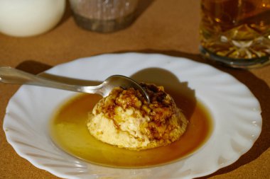 Kaşık, içindeki malzemelerle süslenmiş bir tabakta bira turtasına daldı.