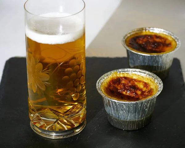Beer flans and a glass of Beer on a black slate board