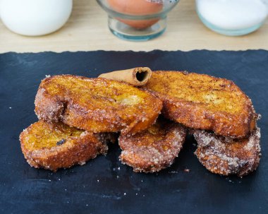 Geleneksel ev yapımı İspanyol Torrijas malzemeleriyle süslenmiş siyah bir tahta üzerinde