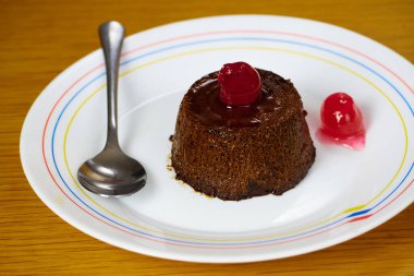 Krem karamel tatlısı mı yoksa kirazlı kahve flanı mı ve tabakta metal kaşık mı?