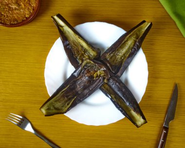 Boş Patlıcan, gümüş çatal bıçak ve yeşil peçeteyle süslenmiş kilden bir kasede bolonez soslu bir tabakta patlıcan. Üst görünüm