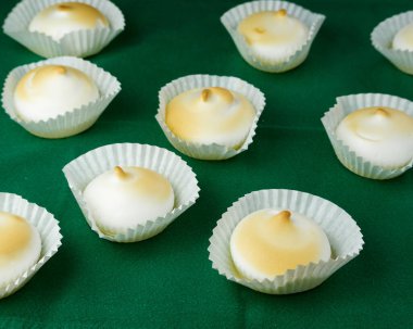 Silikon şekilli yeşil masa örtüsü üzerine birkaç Fransız tatlı kreması.