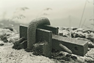 Eski bir metal parçasının siyah beyaz parçası taş bir binaya monte etmek için.