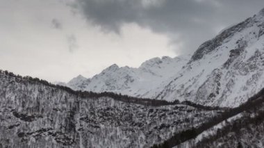 Zaman atlamalı video. Rusya, Kuzey Osetya Cumhuriyeti Alanya. Kışın karlı Kafkas Dağları bulutlarda hareketi.
