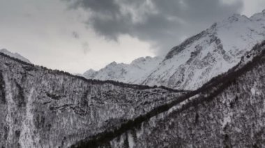 Zaman atlamalı video. Rusya, Kuzey Osetya Cumhuriyeti Alanya. Kışın karlı Kafkas Dağları bulutlarda hareketi.