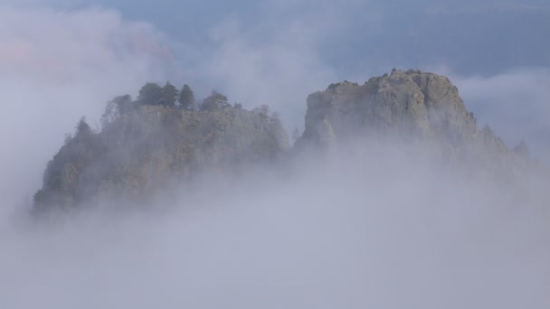 俄罗斯。在早春的雾和云爬上陡峭的山坡的中央高加索密集的面纱山峰. — 图库视频影像