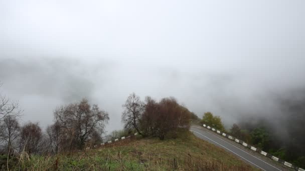 俄罗斯。在早春的雾和云爬上陡峭的山坡的中央高加索密集的面纱山峰. — 图库视频影像