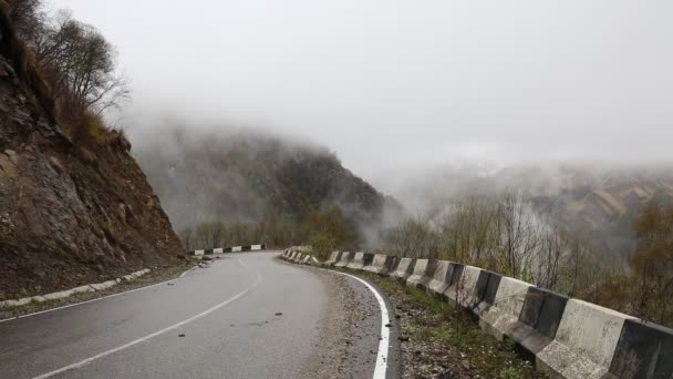 Russia. All'inizio della primavera il fitto velo di nebbia e nuvole striscia sui ripidi pendii montani delle cime del Caucaso centrale . — Video Stock