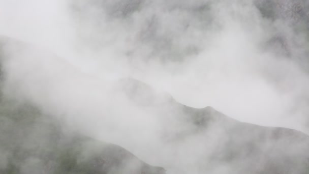 Rusia. A principios de primavera, el denso velo de niebla y nubes trepando por las empinadas laderas de las montañas de los picos del Cáucaso Central . — Vídeos de Stock