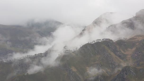 ロシア。春先に霧と雲の中央コーカサス山脈の険しい山の斜面に忍び寄るの密なベールがピークします。. — ストック動画