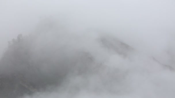 Oroszország. Kora tavasszal a sűrű fátyol-köd és a felhők kúszik felfelé a meredek hegy lejtőin, a központi kaukázusi csúcsok. — Stock videók