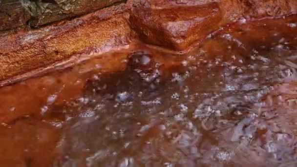 Rusia, la fuente de burbujas de agua mineral hirviendo - seltzer en el pozo con paredes rojas en las montañas de Kabardino-Balkaria — Vídeos de Stock