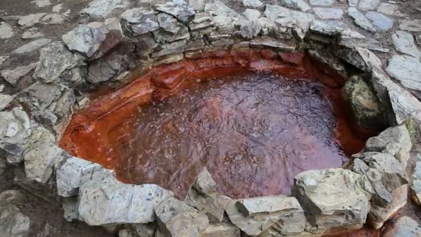 Russia, the source of bubbles of boiling mineral water - seltzer in the well with red walls in the mountains of Kabardino-Balkaria — Stock Video