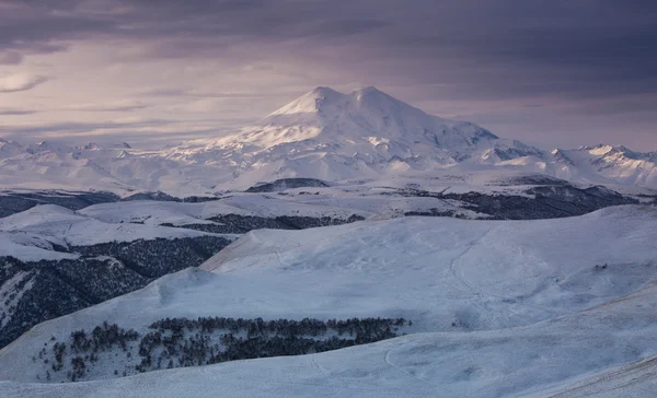 Şafak güneş ışınlarının kışın Elbrus.