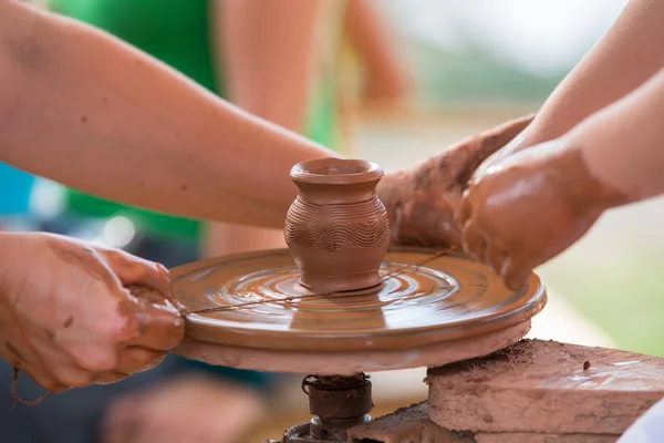 El üstünde a tekerlek seramik sürahi çocuk ha yapmak için yardım