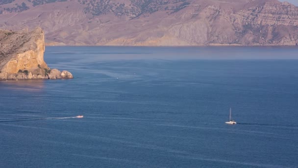 El barco flota en las tranquilas aguas de la bahía del Mar Negro ciudad de Sudak — Vídeo de stock