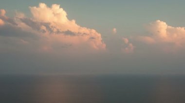 Zaman atlamalı. Rusya, Krasnodar bölgesi. Gün batımında denize pembe cumulus bulutları.