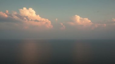 Zaman atlamalı. Rusya, Krasnodar bölgesi. Gün batımında denize pembe cumulus bulutları.