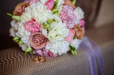 Deri arka planda yüzükler olan düğün buketi