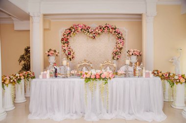 Gelin ve damat masası güzel çiçeklerle süslenmiş.