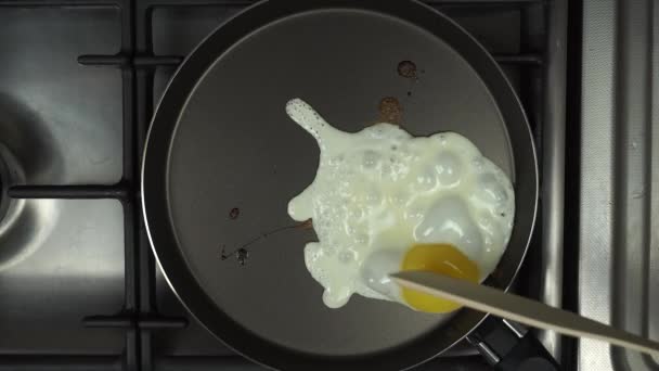 Telur digoreng dalam wajan. Kuning yang rusak dengan spatula — Stok Video
