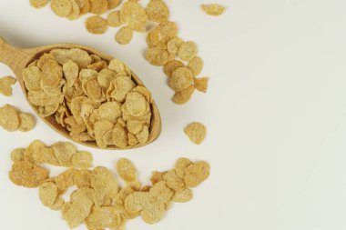 Beyaz zemin üzerinde mısır gevreği olan tahta kaşık.