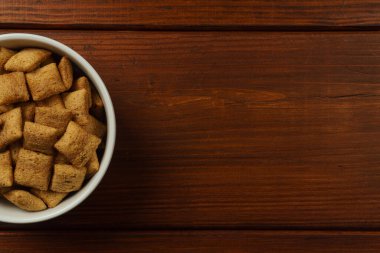 Çikolata dolu kahvaltı pedleri siyah bir masada beyaz bir kasede. Üst görünüm