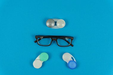 Optik gözlük, mavi arka planda lens kapları, üst görünüm.