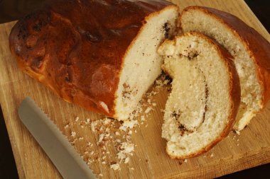 Ahşap arka planda büyük bir çörek parçaları halinde kesilir. Taze ev yapımı hamur işleri..