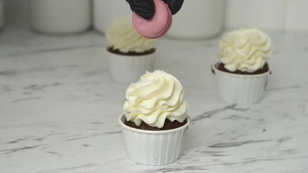 Cocinero pastelero decora el muffin con macaroon.Decorating crema de un muffin — Vídeo de stock